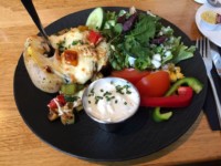 Ofenkartoffel mit frischem Gemüse der Saison und Käse gratiniert, mit Kräuterquark und kleinem Salat